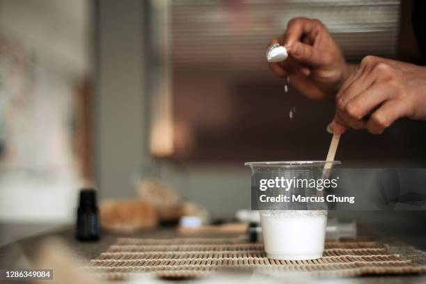 asian chinese female pouring baking soda to a water cup - baking soda stock pictures, royalty-free photos & images