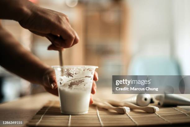 asiatische chinesische frau hält eine tasse und rühren handgemachte zahnpasta - toothpaste stock-fotos und bilder