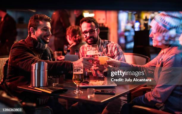 flera vänner njuta av en vinterkväll på terrassen i en bar, öl och drycker toast - alcantara spain bildbanksfoton och bilder