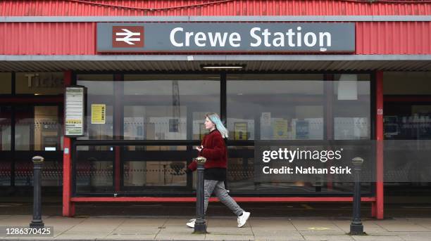 Woman walks past Crewe Train Station on November 18, 2020 in Crewe, Cheshire. The United Kingdom will continue to impose lockdown measures until...