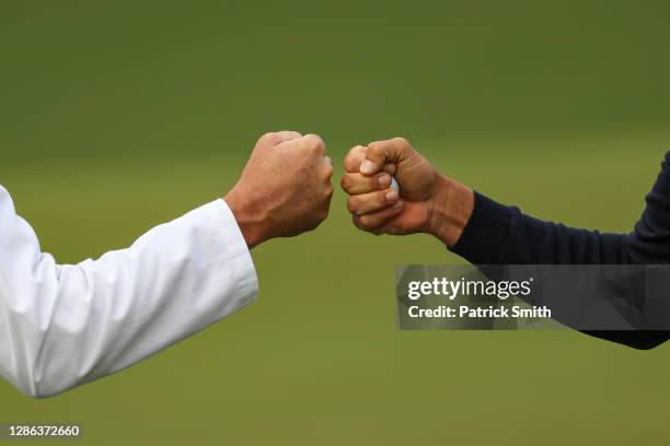 Henrik Stenson of Sweden fist pumps his caddie Glen Murray on the ninth green during round three of the Masters at Augusta National Golf Club on...