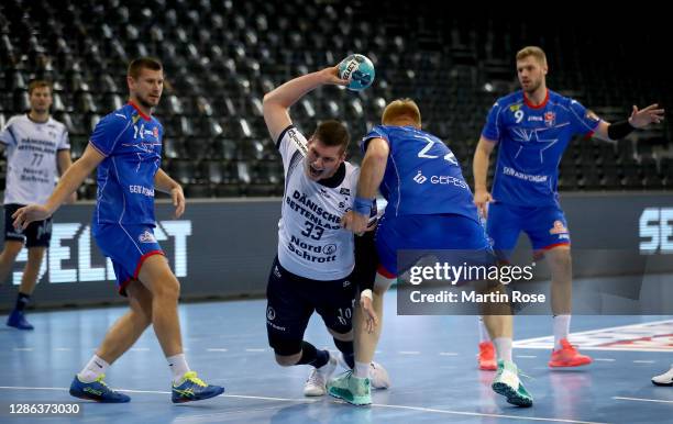 Doman Sikosek of Flensburg challenges Viachaslau Shumak of Brest during the DELO EHF Champions League group stage match between SG Flensburg...