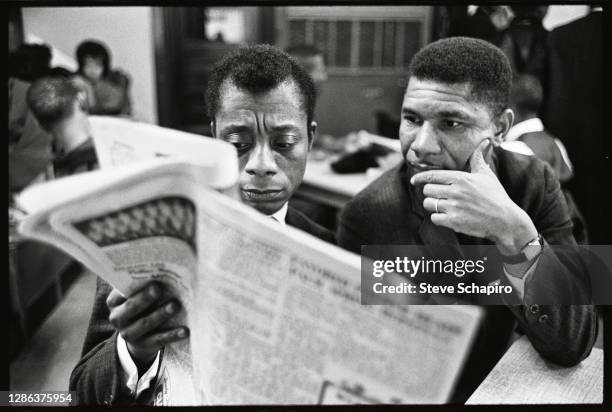 View of American Civil Rights activists writer James Baldwin and the NAACP’s Mississippi field secretary Medgar Evers read a newspaper together,...
