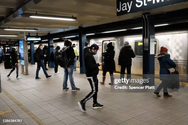 People wait for a subway train at a Brooklyn station on November 18, 2020 in New York City. In a bid to save $1.2 billion, the Metropolitan...