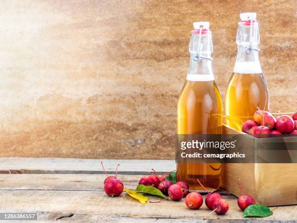 apple juice vinegar with miniature japanese apples on wooden board in morning time - apple cider vinegar stock pictures, royalty-free photos & images
