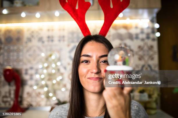 a young woman shaking a snow globe - holding snow globe stock pictures, royalty-free photos & images