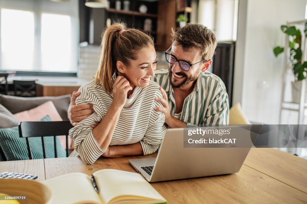 Glückliches Paar mit Laptop zu Hause