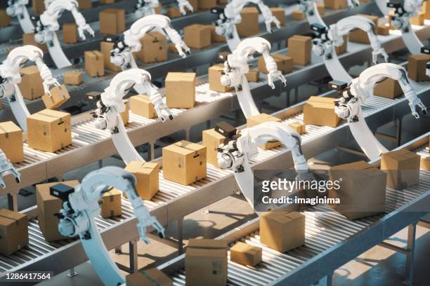 geautomatiseerd magazijn met robotarmen - industrial robotics stockfoto's en -beelden