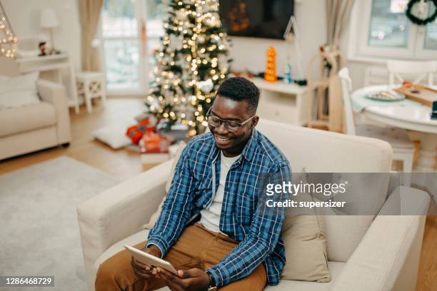 young man working from home during christmas - tree man syndrome stock pictures, royalty-free photos & images