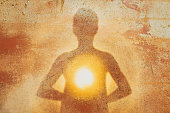 Female silhouette radiating light from within a spiritual heart opening