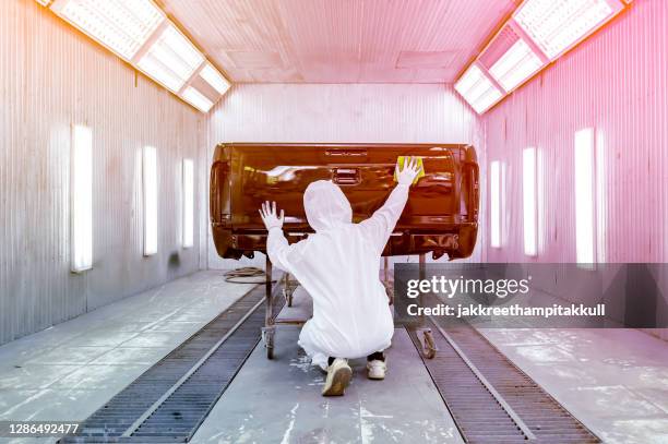 rear view of a man polishing a car's paintwork, thailand - steriler schutzanzug stock-fotos und bilder