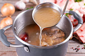 Saucepan with bouillon with a ladle. Bone broth