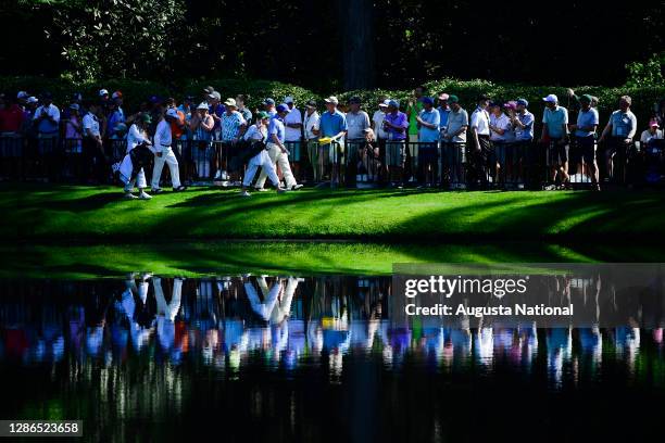 Masters champion Gary Player of South Africa and Masters champion Tom Watson walk past patrons during the Par 3 Contest for the Masters at Augusta...