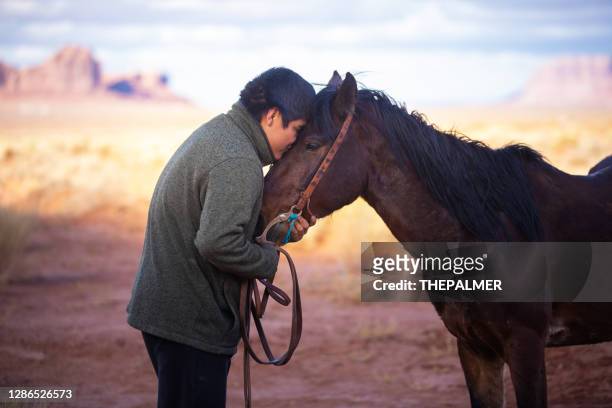 navajo teen showing it love for his horse - boy indian stock pictures, royalty-free photos & images