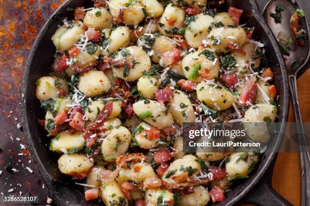 gnocchi with crispy pancetta, sun dried tomatoes and spinach - gnocchi stock pictures, royalty-free photos & images