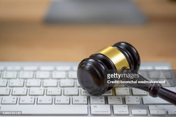 close up of wooden gavel at the computer keyboard - rules stock pictures, royalty-free photos & images
