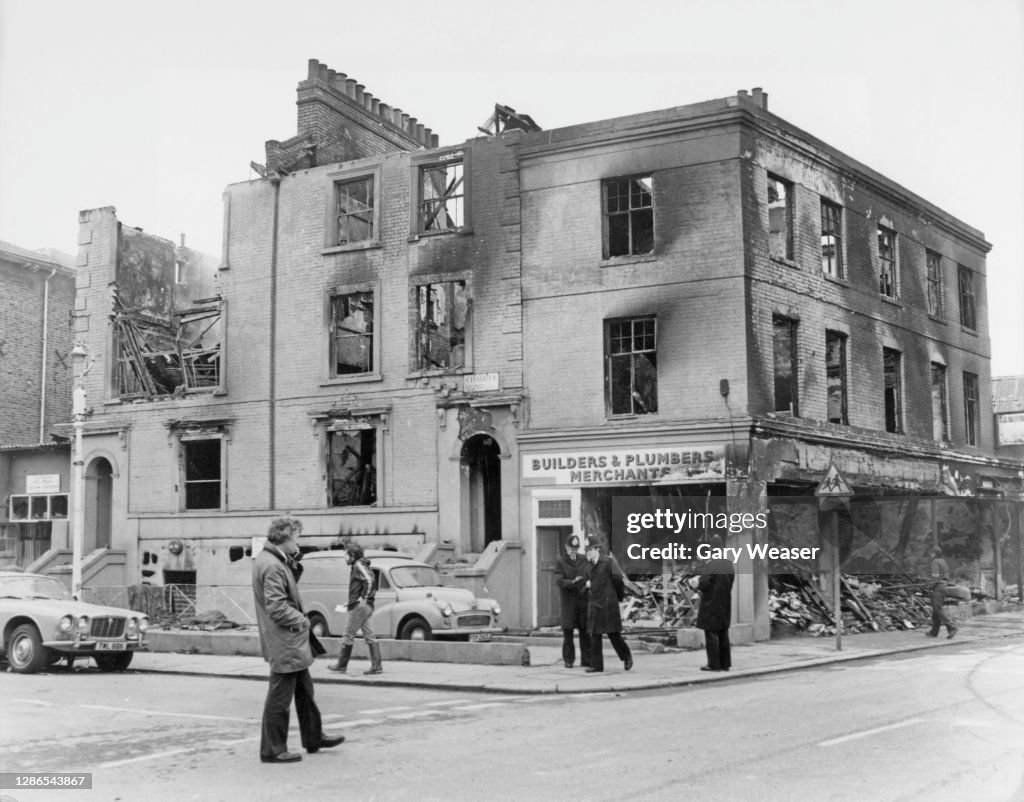 Beixton Riots 1981 Pedestrians and a group of police officers stand before a... News Photo ...