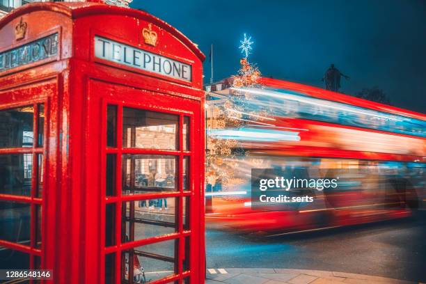cabina telefonica rossa di londra e velocizzare i sentieri leggeri a due piani per strada di notte - london red bus foto e immagini stock