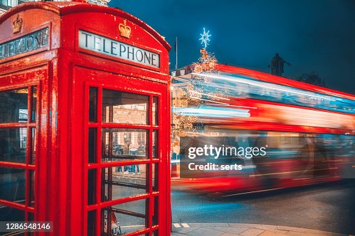 London red telephone booth and speeding double-decker light trails on street at night London red telephone booth and speeding double-decker light trails on street at night