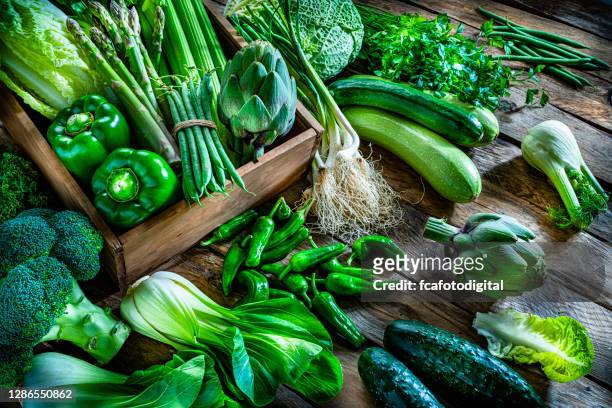 vegan food: healthy fresh green vegetables on rustic wooden table. - leaf vegetable stock pictures, royalty-free photos & images