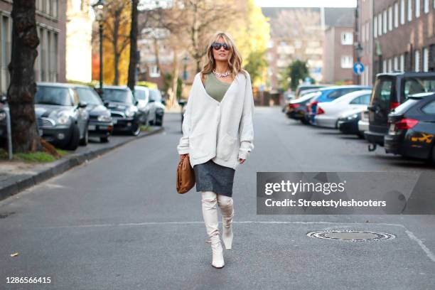 Influencer Gitta Banko wearing cream colored over knee boots by Proenza Schouler, a grey pencil skirt by Gianfranco Ferre, a khaki colored...