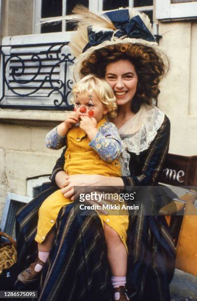 Actor Greta Scacchi takes a break from acting to sit with her daughter, during the filming of 'Jefferson in Paris' in Paris, in 1994.