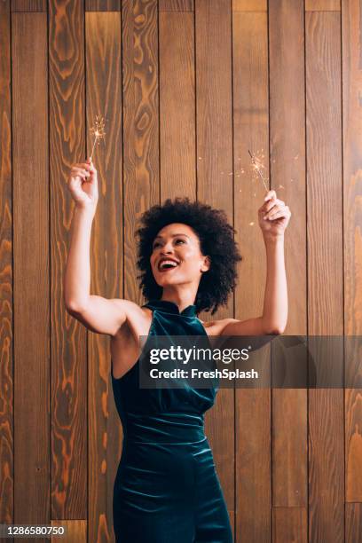 portret van een jonge afrikaanse amerikaanse vrouw die met lit sterretjes bij een partij van kerstmis golft - christmas party dress stockfoto's en -beelden