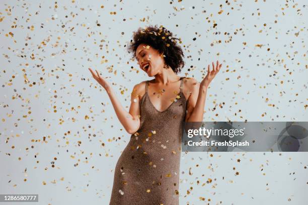 派對時間： 歡快的非洲裔美國年輕女子在五彩雨中跳舞 （白色背景） - 富有魅力 個照片及圖片檔