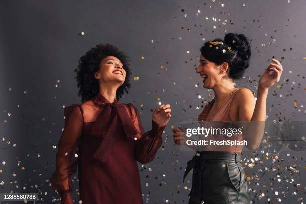 celebration time: happy couple having amazing time at a new year's party, dancing under confetti - black skirt stockfoto's en -beelden