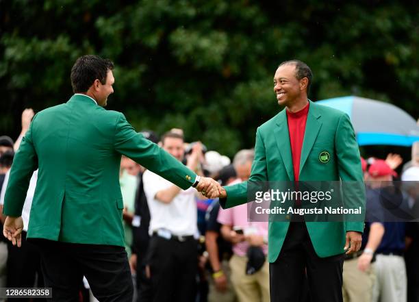 Masters champion Tiger Woods receives his green jacket from Masters champion Patrick Reed after winning the Masters at Augusta National Golf Club,...