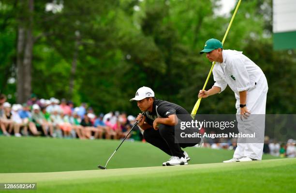 Xander Schauffele and his caddie, Austin Kaiser, lines up a putt on the No. 18 green during the final round of the Masters at Augusta National Golf...