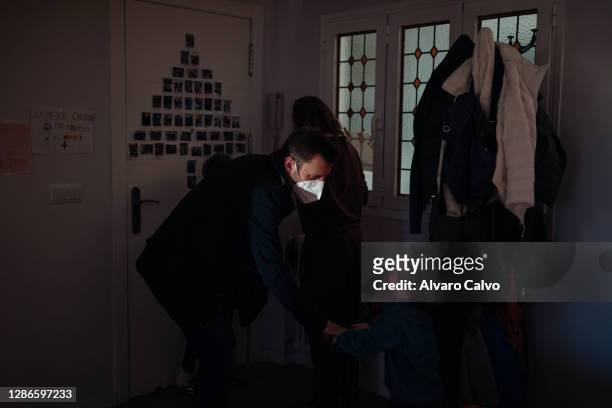 Pablo Sanchez-Rubio and Marta Polo, who are health workers at the San Jorge hospital in Huesca, prepare their sons Juan and Lucas to go from their...