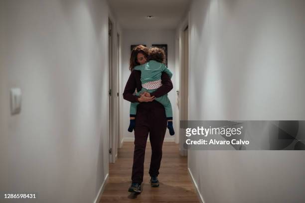 Marta Polo an ICU nurse at the San Jorge Hospital in Huesca, carries her son Lucas down the corridor of her house before going to work on November...