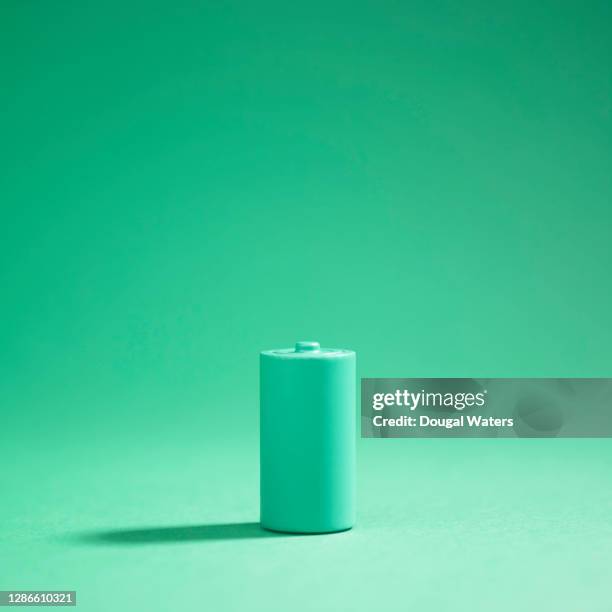 green battery on green background. - battery stock pictures, royalty-free photos & images