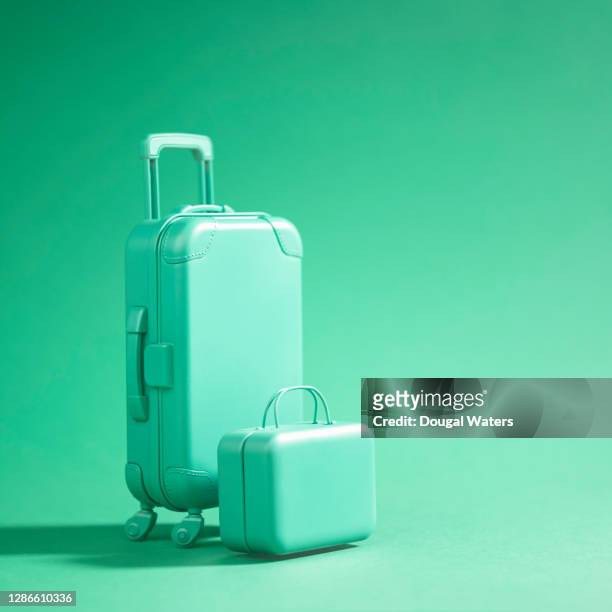 green luggage suitcase on green background. - turismo ecológico fotografías e imágenes de stock