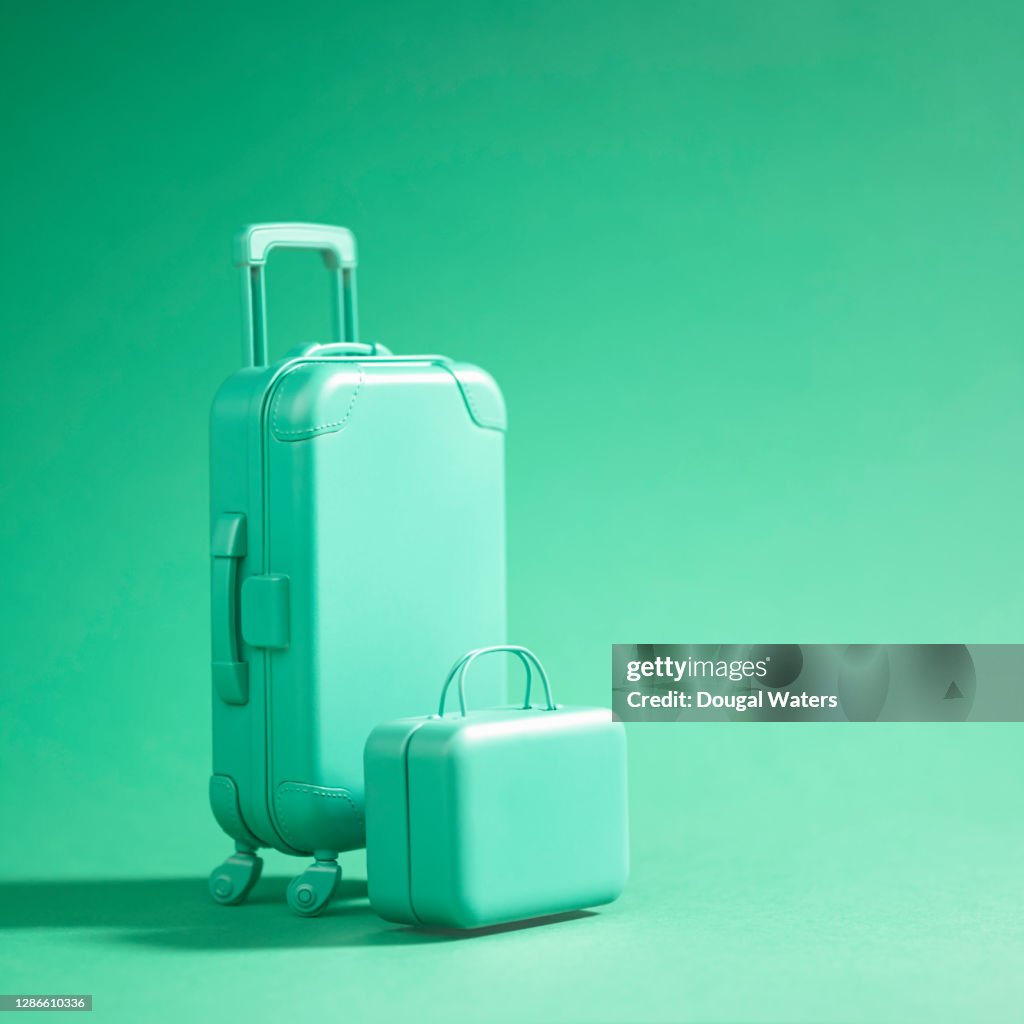 Green luggage suitcase on green background.