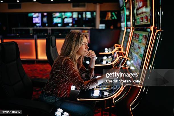 vrouwen die op slotmachines gokken - casino stockfoto's en -beelden