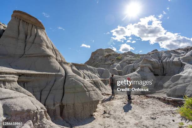 mother and son hiking in badlands of dinosaur provincial park in alberta, canada - alberta badlands stock pictures, royalty-free photos & images