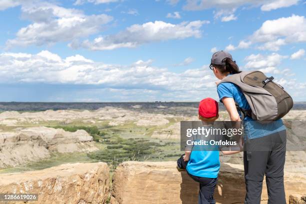 mother and son hiking in badlands of dinosaur provincial park in alberta, canada - alberta badlands stock pictures, royalty-free photos & images