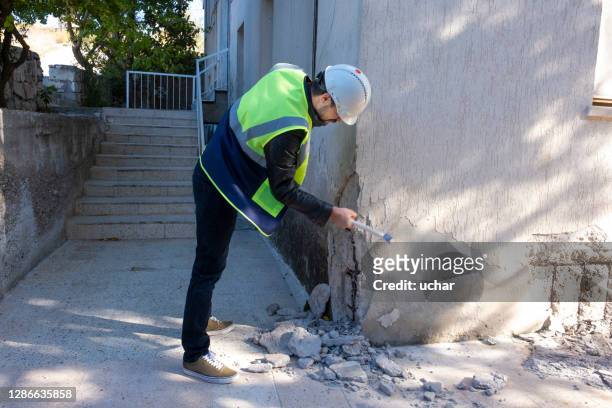 young engineer checks the building after the earthquake - earthquake stock pictures, royalty-free photos & images