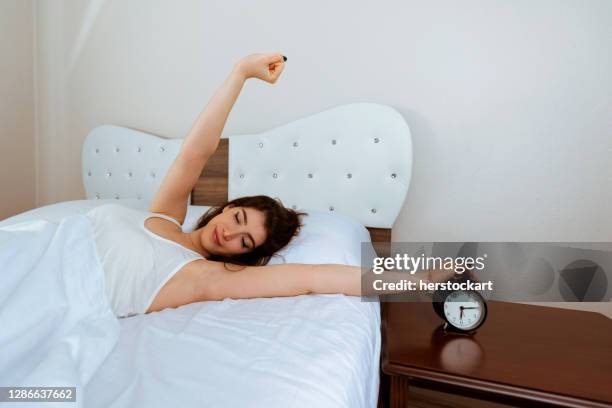 pretty woman waking up stretching in her bed - velorio imagens e fotografias de stock