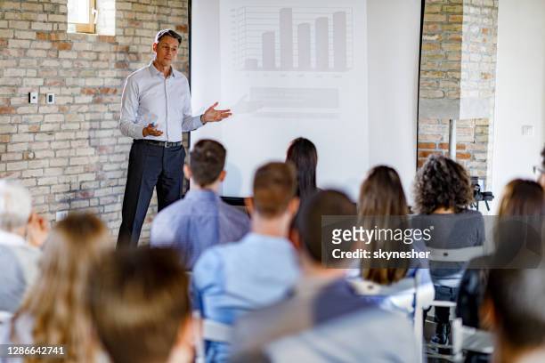 mid adult ceo geeft een presentatie in de bestuurskamer. - presenter stockfoto's en -beelden