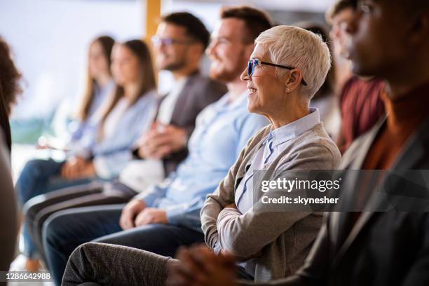 glückliche seniorin bei einem seminar im sitzungssaal. - education retirement stock-fotos und bilder