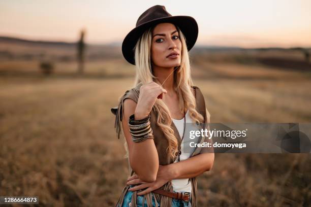 beautiful bohemian styled woman on a sunny day in nature - retro cowgirl stock pictures, royalty-free photos & images
