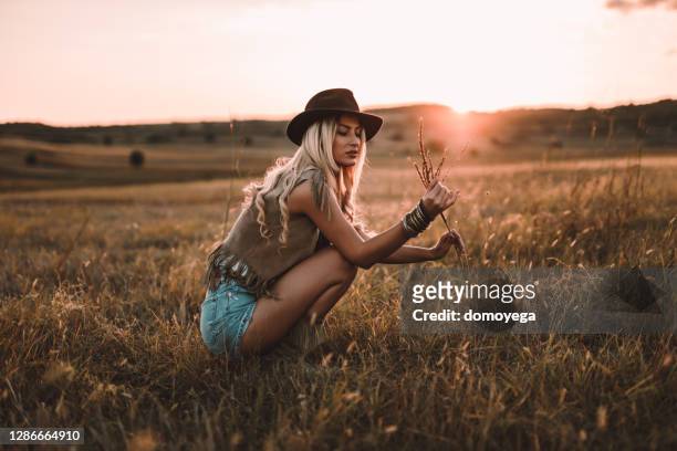 bohemian styled woman enjoying a day in nature - retro cowgirl stock pictures, royalty-free photos & images