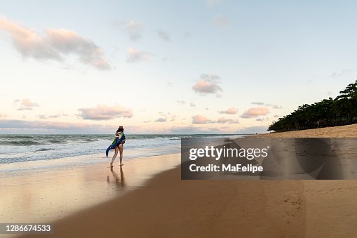 Young girl walking on deserted beach on golden hour in Caraíva, Northeastern Brazil Young girl walking on deserted beach on golden hour in Caraíva, Northeastern Brazil