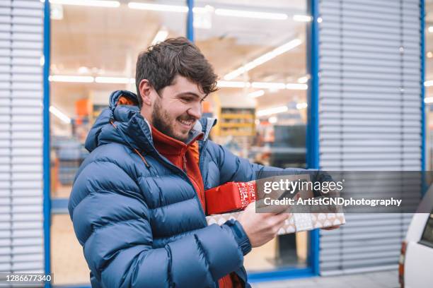 lächelnder junger mann mit smartphone. - sport shop stock-fotos und bilder