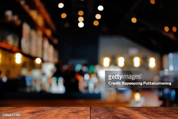 wood table with blur of people in cafe or restaurant on background. - tavolo foto e immagini stock