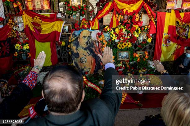 Supporters of Francisco Franco do a fascist salute as flowers, flags and pictures are placed outside the pantheon containing Franco's tomb at El...