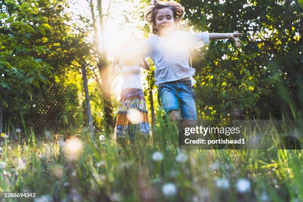 glückliche familie genießt das gute wetter im hinterhof - kind blume stock-fotos und bilder